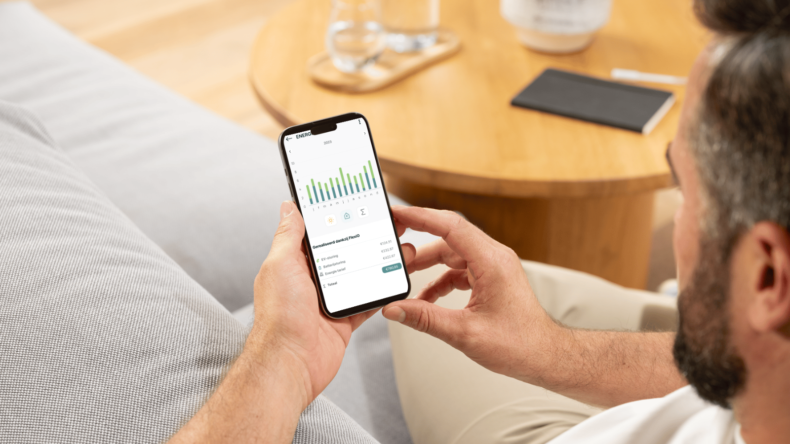 Man in de zetel die dynamische prijzen bekijkt op zijn gsm