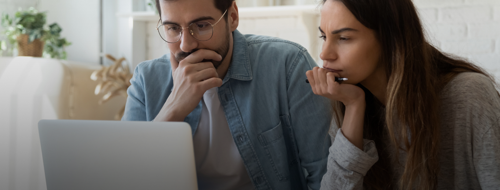 Man en vrouw kijken nadenkend naar computerscherm