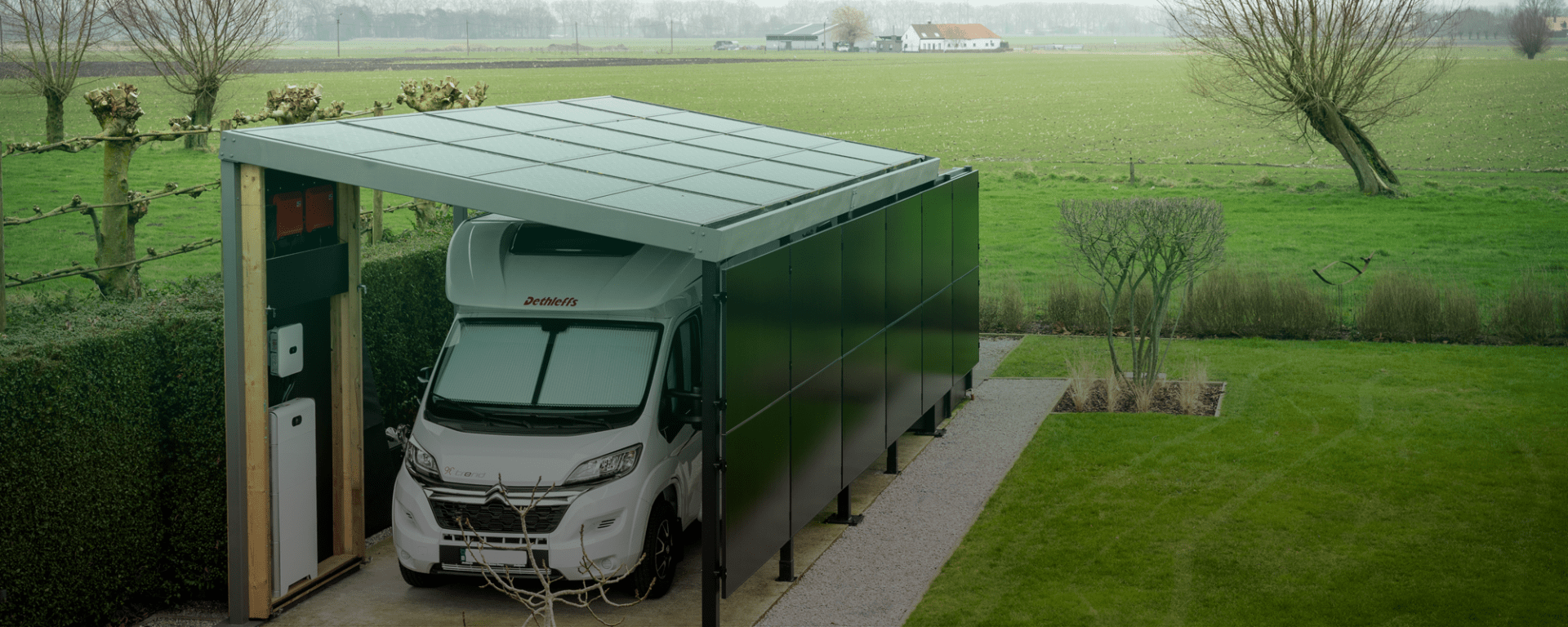 Tuin met een carport voor een camper met zonnepanelen op het dak